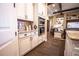 White kitchen cabinets, granite countertop, view into living room at 41516 Saddle Ridge Ln, Weirsdale, FL 32195