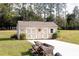 Tan storage shed with double doors, window, and landscaping at 41516 Saddle Ridge Ln, Weirsdale, FL 32195