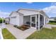 White house with a screened porch and landscaped yard at 424 Rose Croft Ter, The Villages, FL 32162