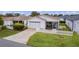 White house with garage, screened porch, and picket fence. Landscaped lawn and driveway at 424 Rose Croft Ter, The Villages, FL 32162