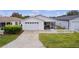 Front view of a house with a white picket fence and driveway at 424 Rose Croft Ter, The Villages, FL 32162