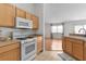 Bright kitchen featuring gas range, microwave and ample counter space with light colored cabinets at 424 Rose Croft Ter, The Villages, FL 32162