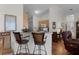 Kitchen with breakfast bar and view into living room with leather recliner at 424 Rose Croft Ter, The Villages, FL 32162