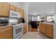 Kitchen features white appliances and light wood cabinets at 424 Rose Croft Ter, The Villages, FL 32162