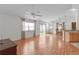 Open-concept living room features a ceiling fan, wood floors, and sliding door access to the yard at 424 Rose Croft Ter, The Villages, FL 32162