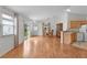 Bright living room with wood floors, neutral walls, and an adjacent dining area and partial kitchen at 424 Rose Croft Ter, The Villages, FL 32162