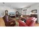 Bright living room featuring a brown sofa and two red armchairs at 424 Rose Croft Ter, The Villages, FL 32162