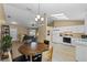 Open concept kitchen and dining area with white cabinets and wood-look floors at 438 Woodview Dr, Tavares, FL 32778