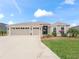 Three-car garage and attractive landscaping enhance this home's curb appeal at 4406 Creighton Loop, The Villages, FL 32163