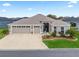 Single-story house featuring a three-car garage and well-manicured lawn at 4406 Creighton Loop, The Villages, FL 32163