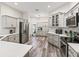 Modern kitchen with white cabinets, stainless steel appliances, and a herringbone backsplash at 4406 Creighton Loop, The Villages, FL 32163