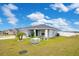 One-story home with gray siding, lush lawn, and palm trees at 4518 Hummingbird Ln, Haines City, FL 33844