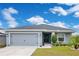 Gray house with a two-car garage and landscaped lawn at 4518 Hummingbird Ln, Haines City, FL 33844