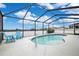 Relaxing kidney-shaped pool with screened enclosure and patio chairs at 4518 Hummingbird Ln, Haines City, FL 33844