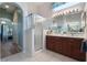 Elegant bathroom with double vanity, shower, and view of the bedroom at 4928 Kelso St, Leesburg, FL 34748