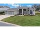 House with three-car garage, screened porch, and lush green lawn at 4928 Kelso St, Leesburg, FL 34748