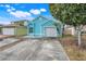 Cute teal house with a two-car garage and a small front yard at 500 Southern Charm Dr, Orlando, FL 32807