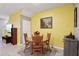 Dining area with round table and four chairs, yellow walls, and artwork at 5278 Dragonfly Dr, Wildwood, FL 34785