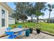 Cozy patio with blue chairs and a table, surrounded by greenery at 5318 Fantasy Way, Leesburg, FL 34748