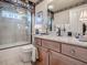 Bathroom with granite countertop vanity, glass shower, and neutral tile floors at 581 Society Hill Cir, The Villages, FL 32162