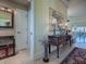 Elegant entryway with wood console table, mirror, and oriental-style decor at 581 Society Hill Cir, The Villages, FL 32162