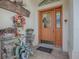 Inviting entryway with an orange door, autumn wreath, and glass-top console table at 581 Society Hill Cir, The Villages, FL 32162