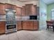 Well-equipped kitchen with stainless steel appliances and wood cabinets at 581 Society Hill Cir, The Villages, FL 32162