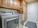 Laundry room with modern washer and dryer and wood cabinets at 581 Society Hill Cir, The Villages, FL 32162