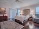 Main bedroom with a queen bed, sliding glass doors, and hardwood floors at 581 Society Hill Cir, The Villages, FL 32162