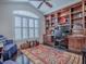 Home office with built-in bookshelves, a desk, and a large window with shutters at 581 Society Hill Cir, The Villages, FL 32162