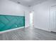 Bedroom with teal geometric accent wall and gray floors at 808 E Orange St, Apopka, FL 32703