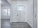 Interior view of entryway with white door and gray flooring at 808 E Orange St, Apopka, FL 32703