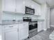 White cabinets, granite countertops, and stainless steel appliances at 808 E Orange St, Apopka, FL 32703