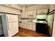 Cozy kitchen featuring white cabinets, wood floors, and appliances at 819 Edgewater Dr, Eustis, FL 32726