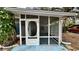 White screened porch with a vintage door and wood siding at 819 Edgewater Dr, Eustis, FL 32726