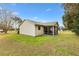 Tan house exterior, showcasing the backyard and screened porch at 860 Evelynton Loop, The Villages, FL 32162