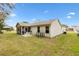 Tan house exterior with screened porch and grassy backyard at 860 Evelynton Loop, The Villages, FL 32162