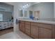 Bathroom featuring double sinks, wood cabinets, granite countertops, and tile flooring at 963 Hart Dr, The Villages, FL 32163