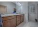 Bathroom featuring double sinks, a granite countertop, and a tiled walk-in shower at 963 Hart Dr, The Villages, FL 32163