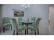 Cozy dining area with glass table and four chairs, featuring wall art at 963 Hart Dr, The Villages, FL 32163