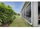 Exterior view of the covered lanai and the edge of manicured lawn and shrubbery at 963 Hart Dr, The Villages, FL 32163