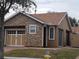 Tan house with stone facade, two-car garage, and landscaped yard at 97 Bayou Bend Rd, Groveland, FL 34736