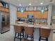 Modern kitchen with light wood cabinets and breakfast bar at 97 Bayou Bend Rd, Groveland, FL 34736