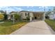 Well-maintained manufactured home with carport and landscaping at 1007 Dustin Dr, The Villages, FL 32159