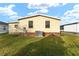 Rear view of house showing exterior condition and lawn at 1007 Dustin Dr, The Villages, FL 32159