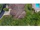 Overhead shot of terracotta tiled roofing with lush treetop landscape, community pool, and two-car driveway at 102 Camino Real Blvd # 102, Howey In The Hills, FL 34737