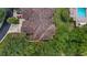 Overhead shot of terracotta tiled roofing with lush treetop landscape, community pool, and two-car driveway at 102 Camino Real Blvd # 102, Howey In The Hills, FL 34737