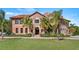 Mediterranean-style home with palm trees and manicured lawn at 102 Camino Real Blvd # 102, Howey In The Hills, FL 34737