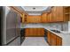 Modern kitchen boasts wood cabinets, stainless steel appliances, and ample counter space at 102 Camino Real Blvd # 102, Howey In The Hills, FL 34737
