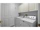 Laundry room with washer, dryer, and storage cabinets at 102 Camino Real Blvd # 102, Howey In The Hills, FL 34737